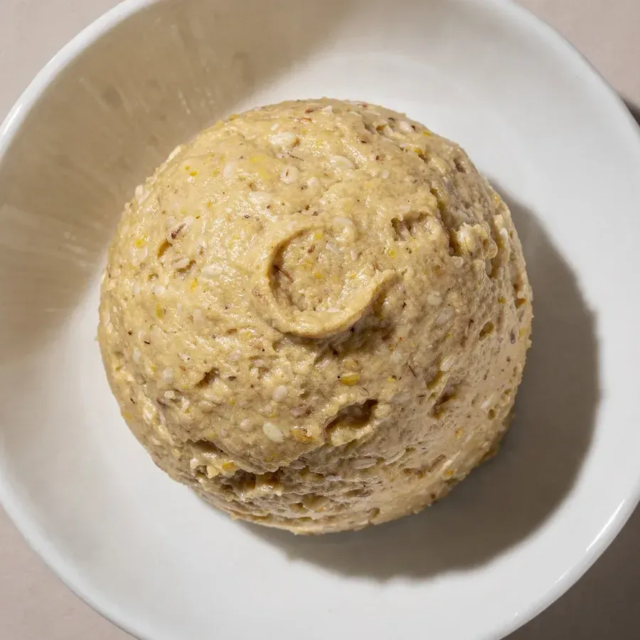 Ljust gulbeige mugi-miso med synliga kornbitar i en vit skål