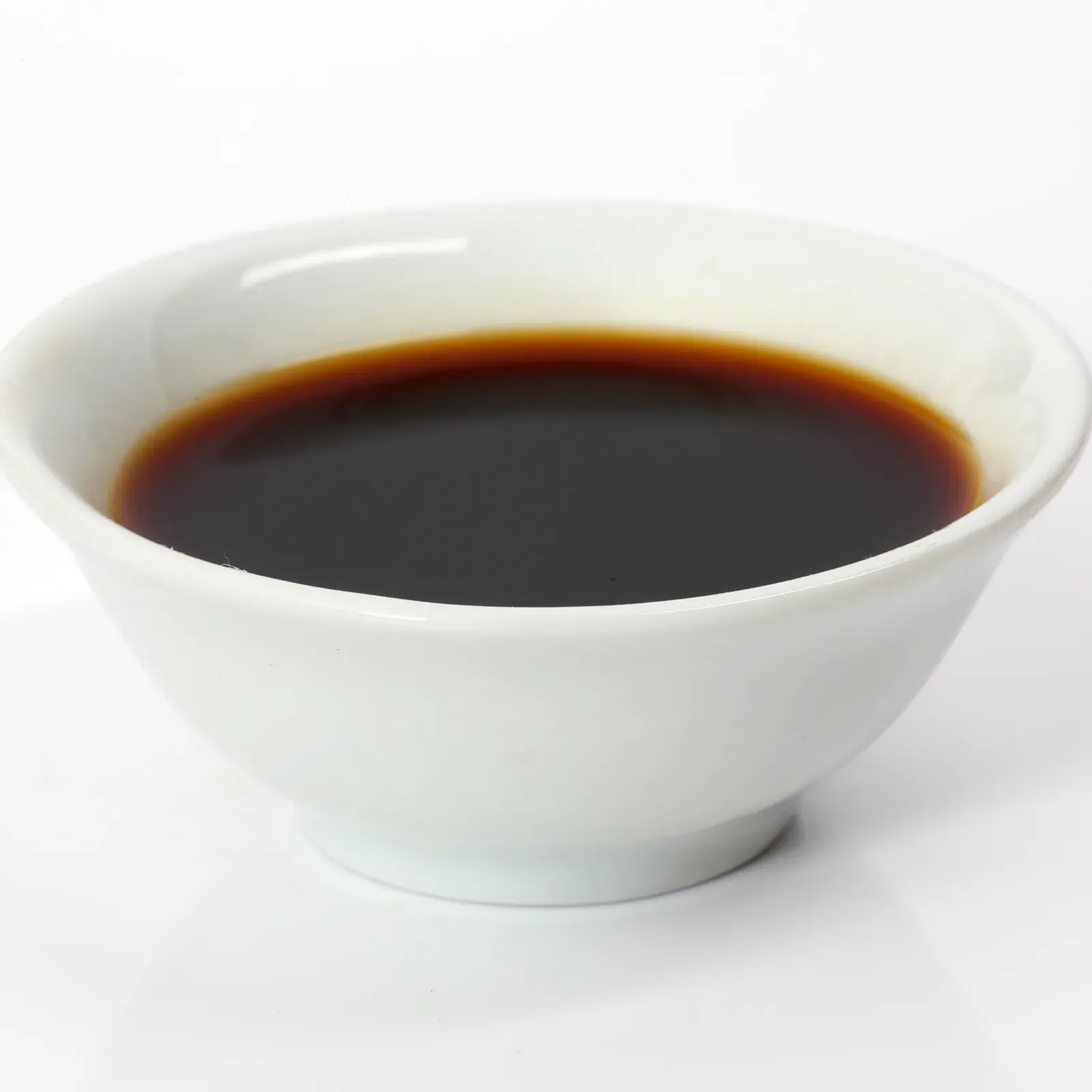 Japansk soja i en liten vit skål mot vit bakgrund